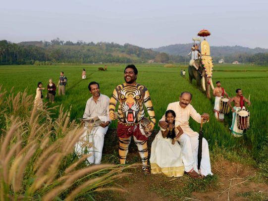 man painted with a tiger on his belly during a procession in field in Kerala for Kerala Tourism Campaign by Joey L.