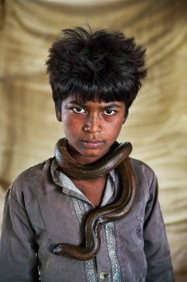 Boy with a snake around his neck