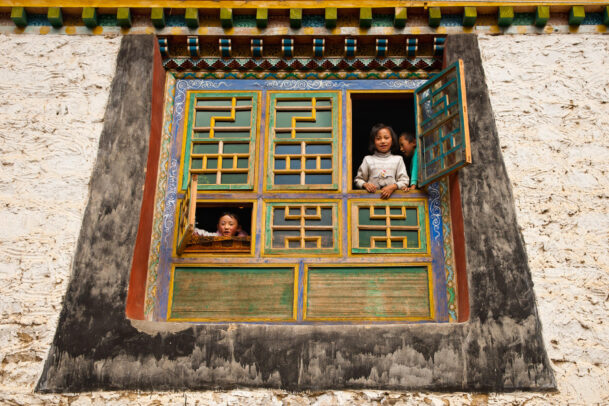 children at a window in Tibet