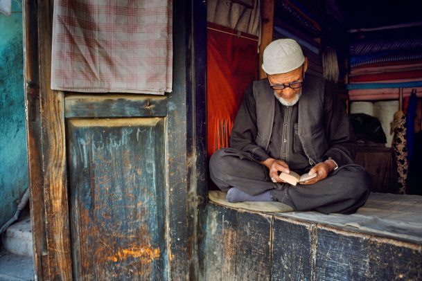 fabric vendor man sits and reads a book