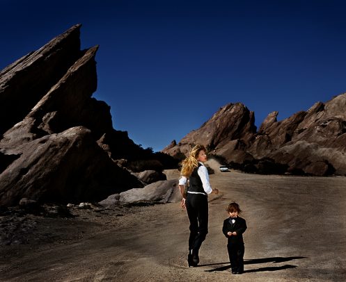 woman walking in mountain setting with a child