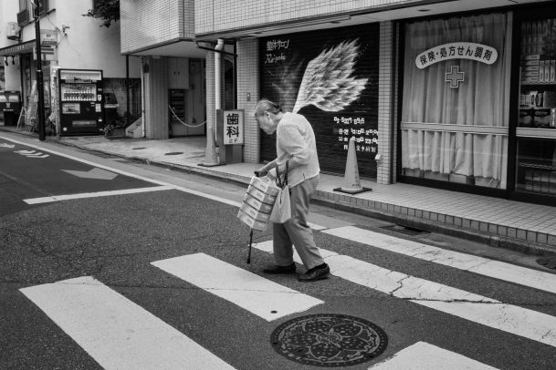 old lady with wings walking in the street
