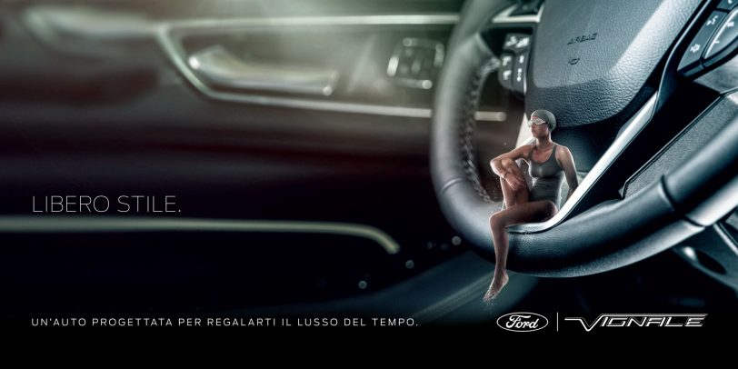 ford advertising with little woman sitting on the steering wheel