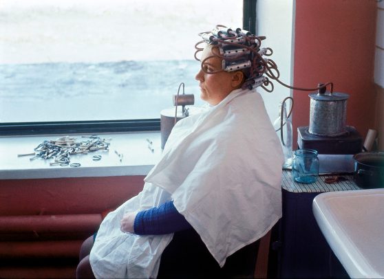 woman sitting with tubes for hair on her head