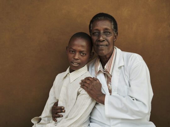 a doctor and his young patient posing for Novartis annual report by Joey L.