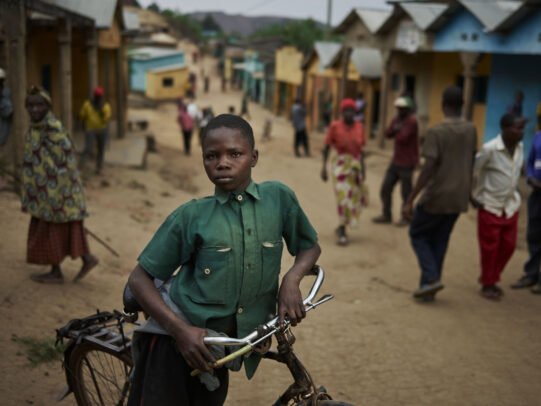 boy with his bicycle in an ethiopian street during Novartis annual report by Joey L.
