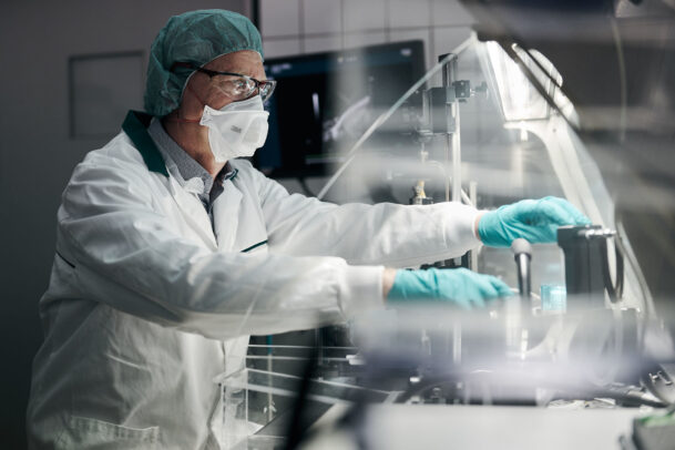 a doctor with mask, cap and gloves in laboratory during Novartis annual report by Joey L.