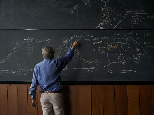 a professor indicating the board with charts during Novartis annual report by Joey L.