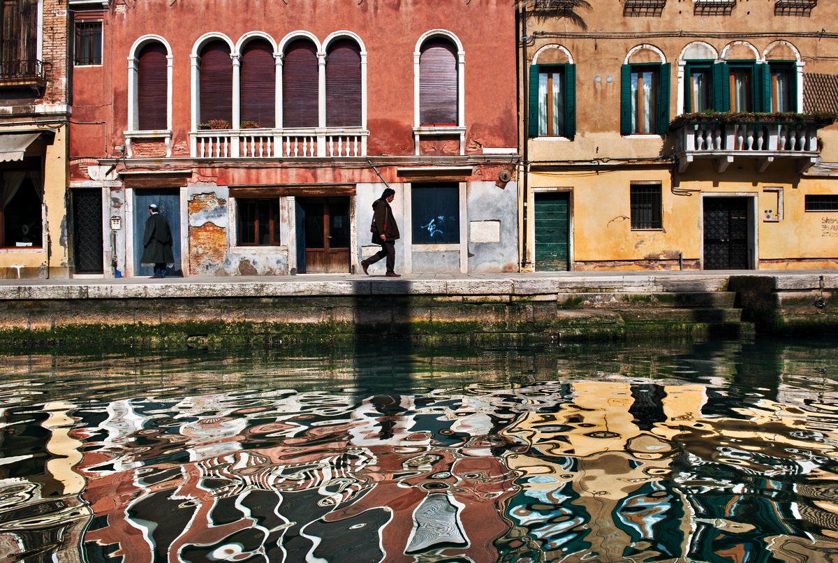 colorful venetian buildings' reflections in a canal