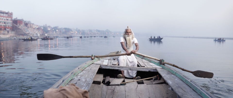old man on a boat of a river in India