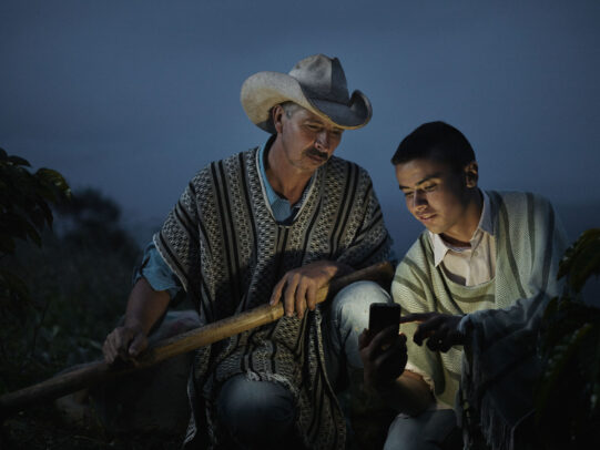 a boy showing to his father something on his phone at dusk for Lavazza Calendar 2016 by Joey L