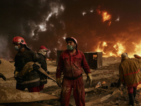Firemen working to estinguish fire from an oil well in Iraq