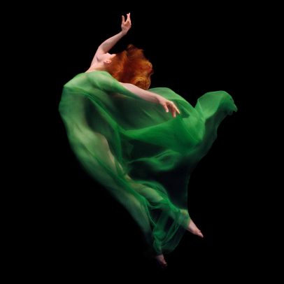 redhead girl dancing underwater with a green dress