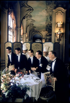 waiters in a luxury restaurant looking outside a window