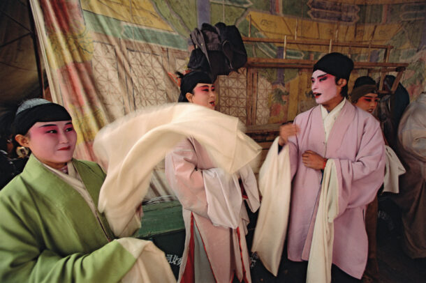 chinese singers in an opera troupe wait to perform