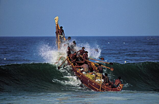 Traditional Indian fishing boat on a wave