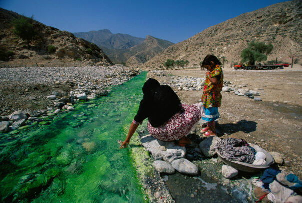 woman and her daughter near a creek in a desert area