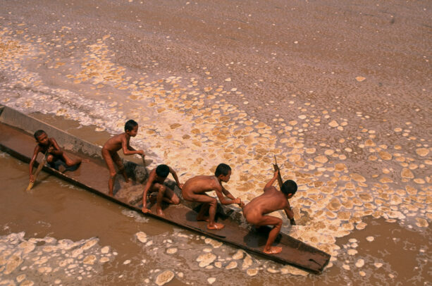boys playing polluted waters