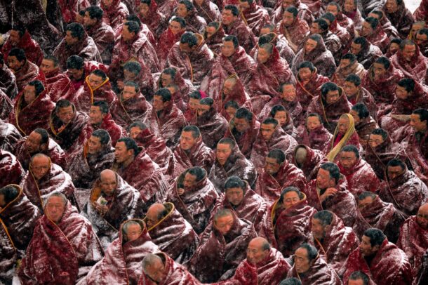 Heedless of a blizzard, monks await the start of morning prayers in Labrang Monastery, Tibet.