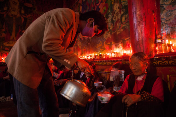 man pouring tea to an old lady