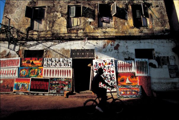 crumbling building in Zanzibar with paintings leaning against his walls