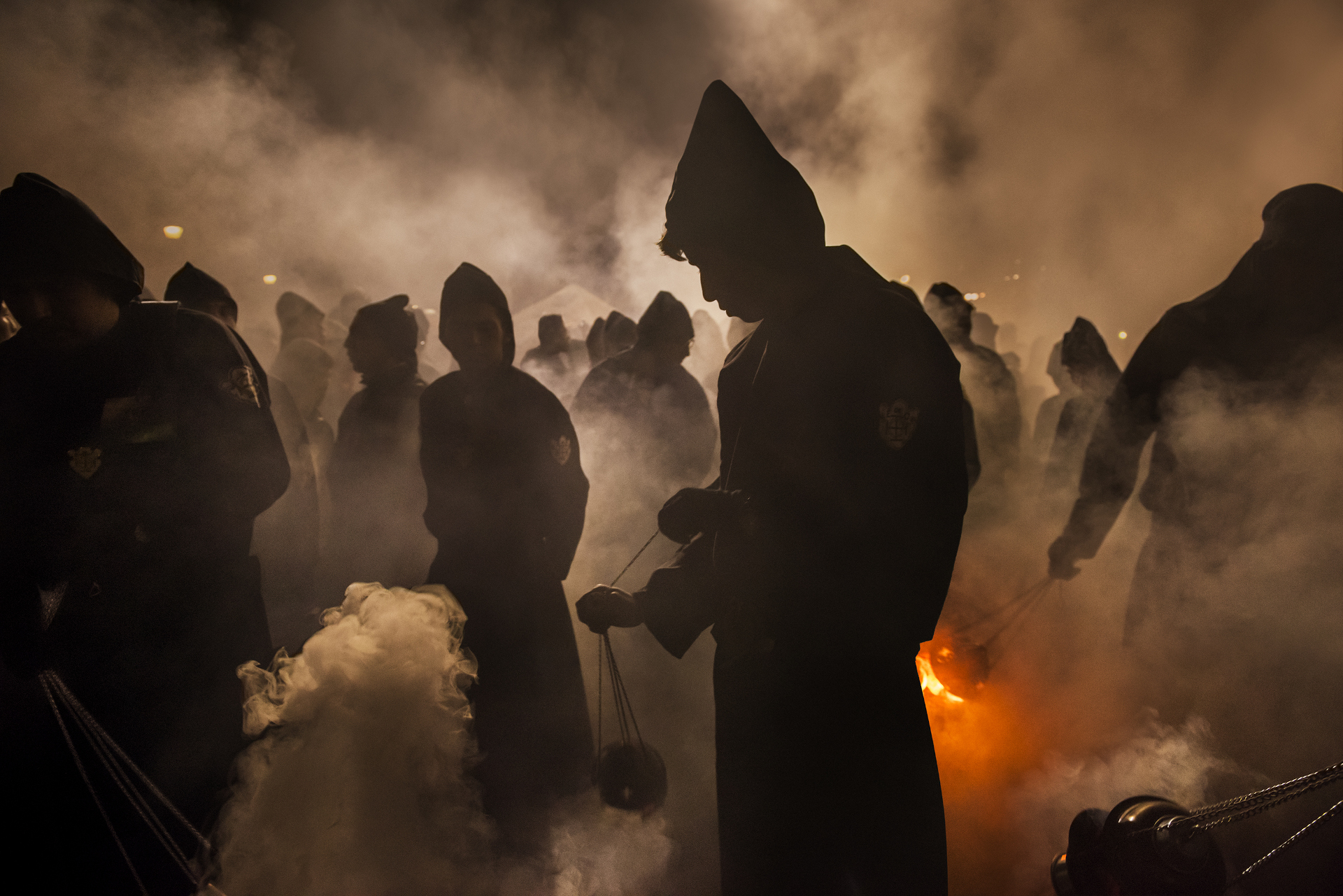 figures through smoke and fire of a catholic procession in Guatemala